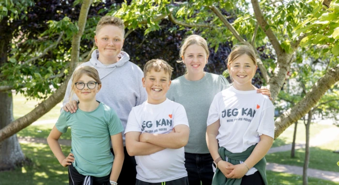 Fem børn på Liljeborg står under et træ i haven på Julemærkehjemmet