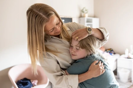 En pædagog og et barn på Julemærkehjem krammer